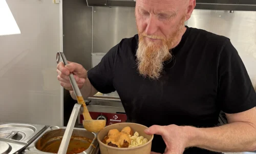 Photo de Eric qui verse de la sauce sur les boulettes