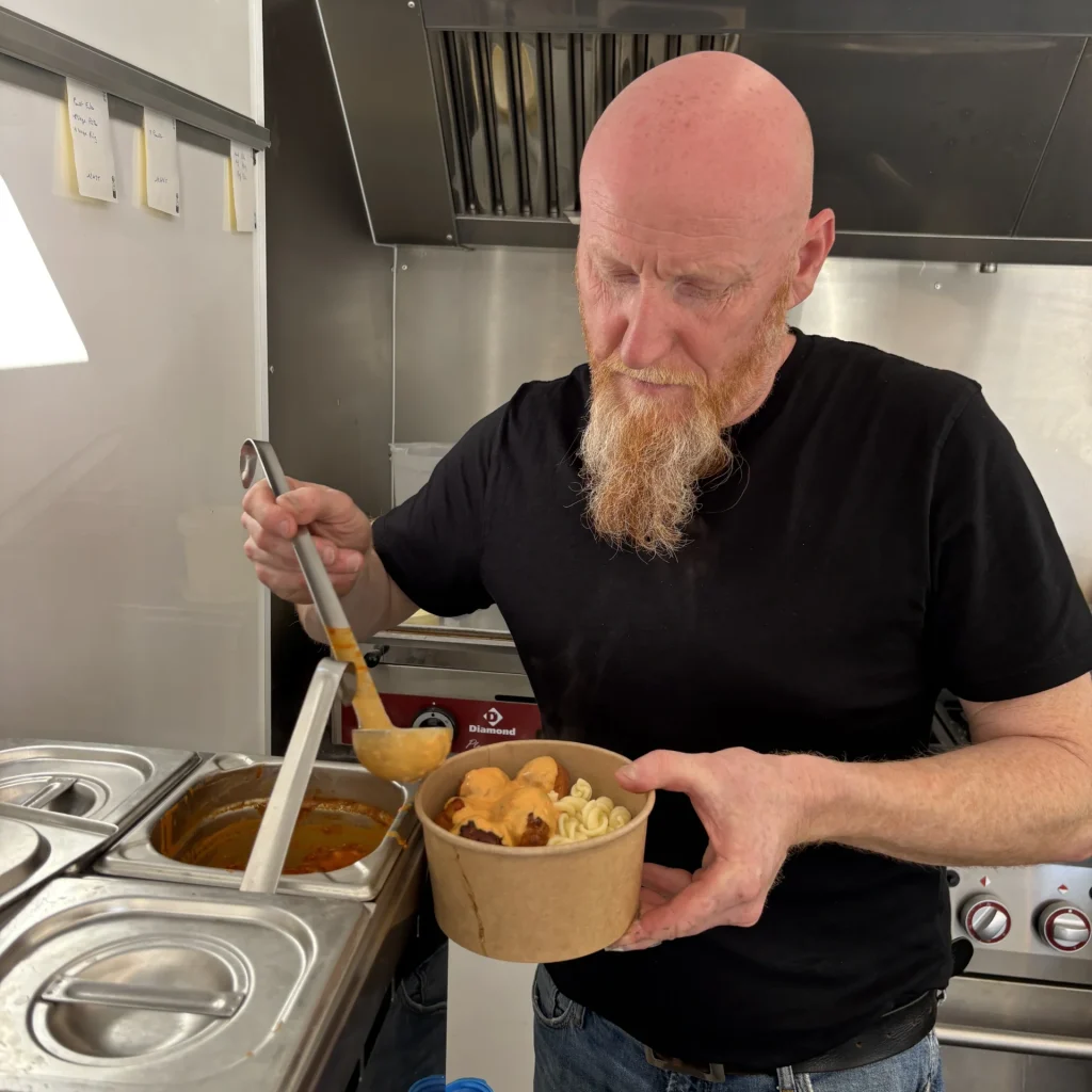 Photo de Eric qui verse de la sauce sur les boulettes