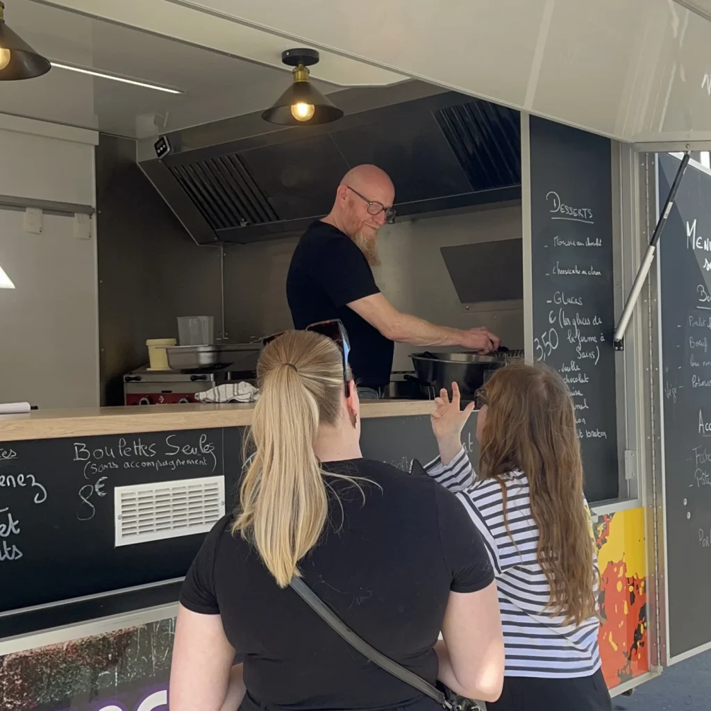 Photo de Eric qui sert des clientes lors d'un événement